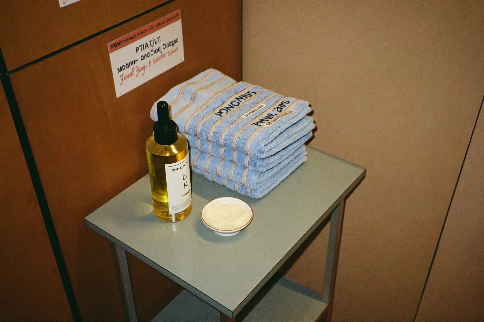 Massage oil, balm and folded towels on a side table