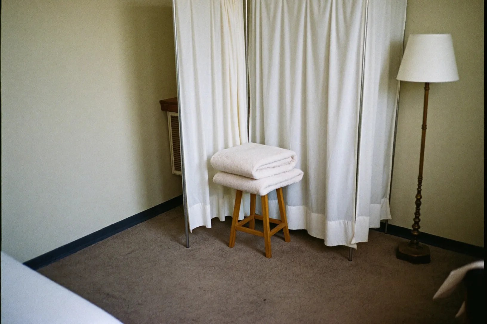 Curtained corner of the treatment room with a stool and folded blanket