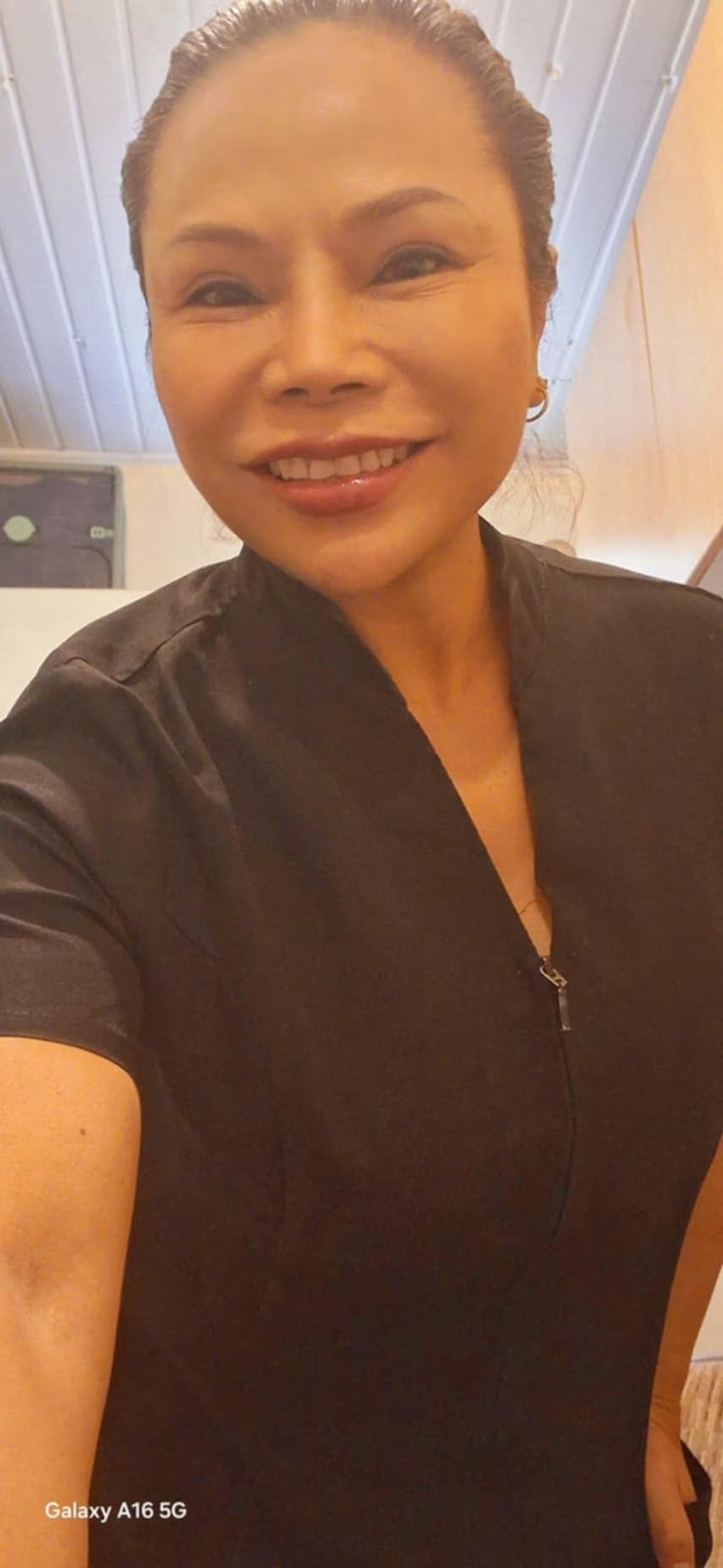 Therapist in a dark tunic in the softly lit treatment room at Nana Thai Thai Massage